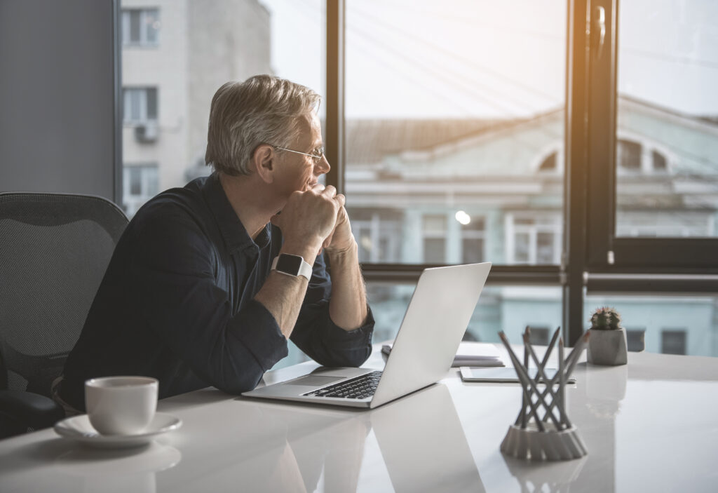 Pensive,Mature,Businessman,Having,Job,With,Laptop,While,Looking,At